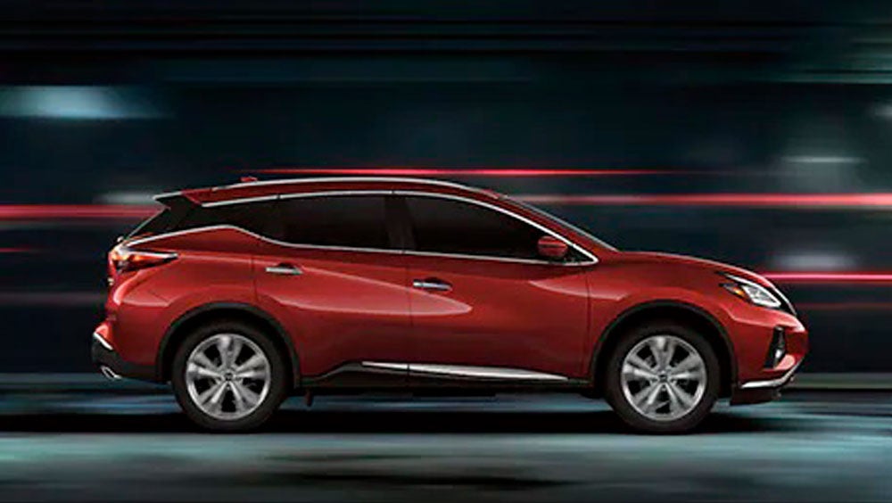 2023 Nissan Murano shown in profile driving down a street at night illustrating performance. | Petro Nissan in Hattiesburg MS